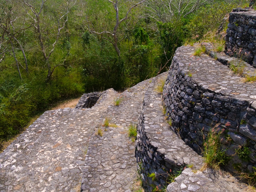 a stone wall with a grassy area in the background