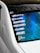 The rear window of a white car features several automotive brand decals including Woofer, Brembo, Seibon Carbon, Recaro, Enkei, and Air Lift Performance. The background of the window has a blue gradient design. Additionally, there is a Nürburgring track outline sticker.