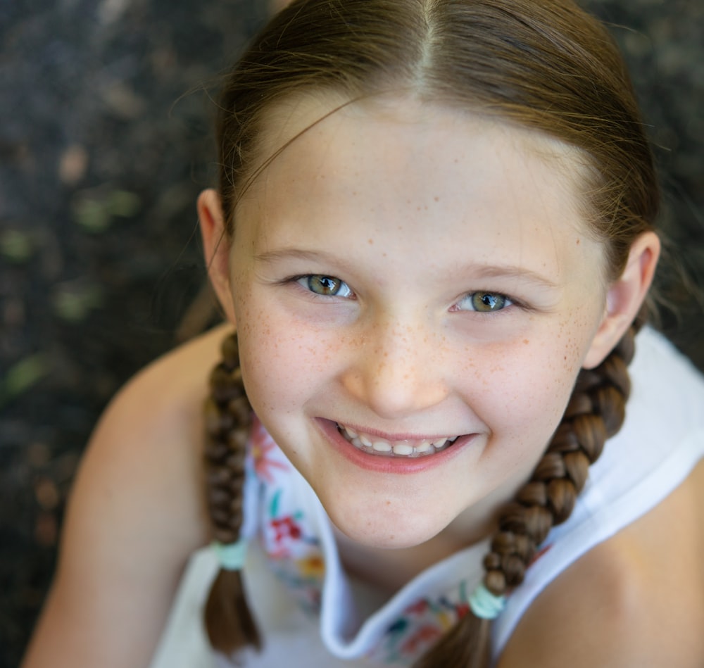 a young girl with braids smiling at the camera