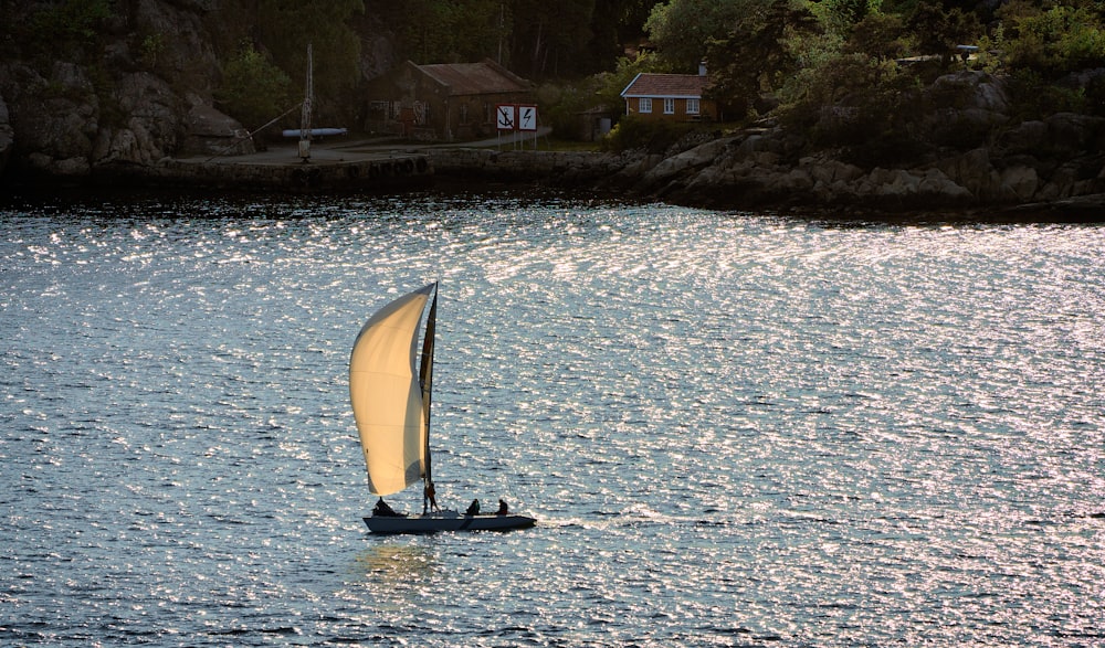 a sailboat with a yellow sail is in the water