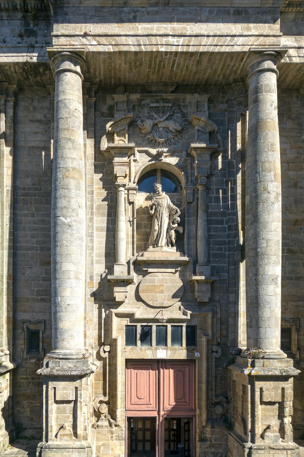 a large stone building with a red door