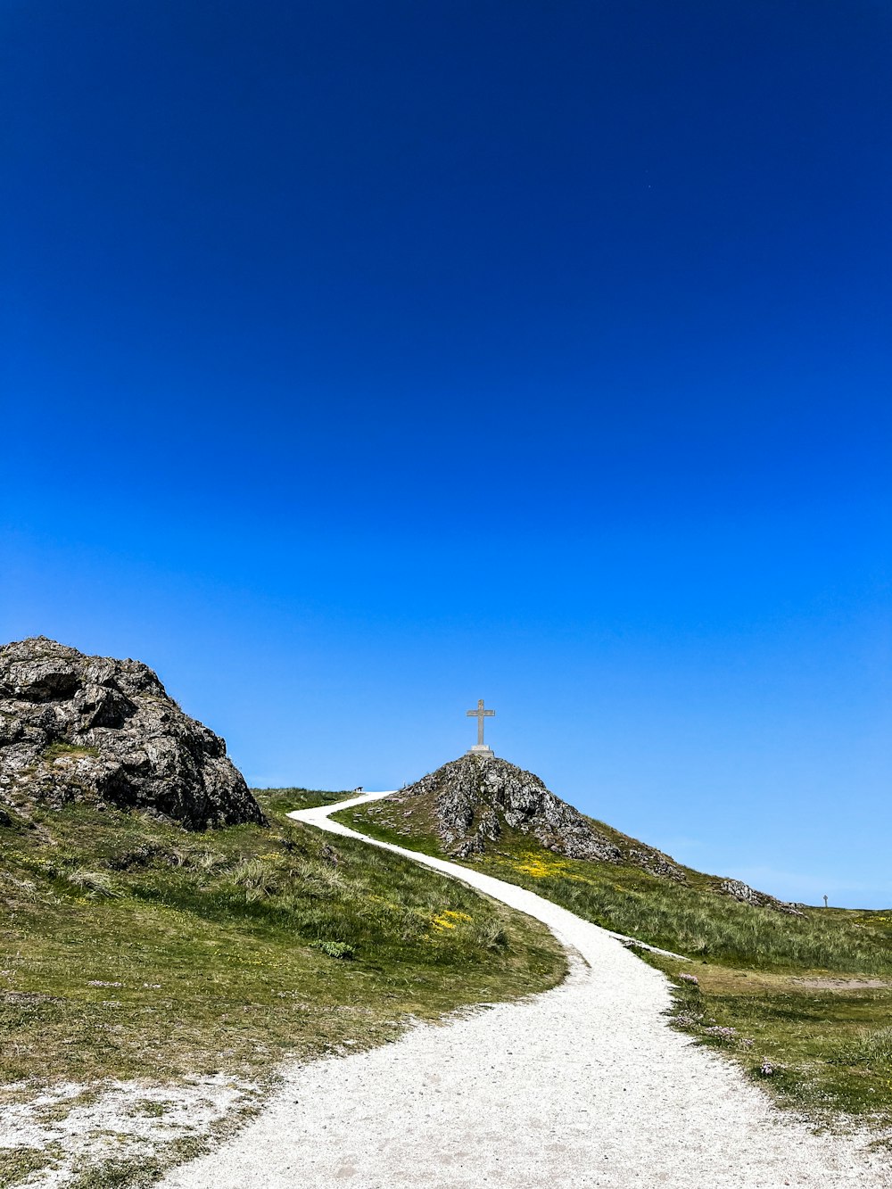 a cross on top of a hill on a [UNK] day