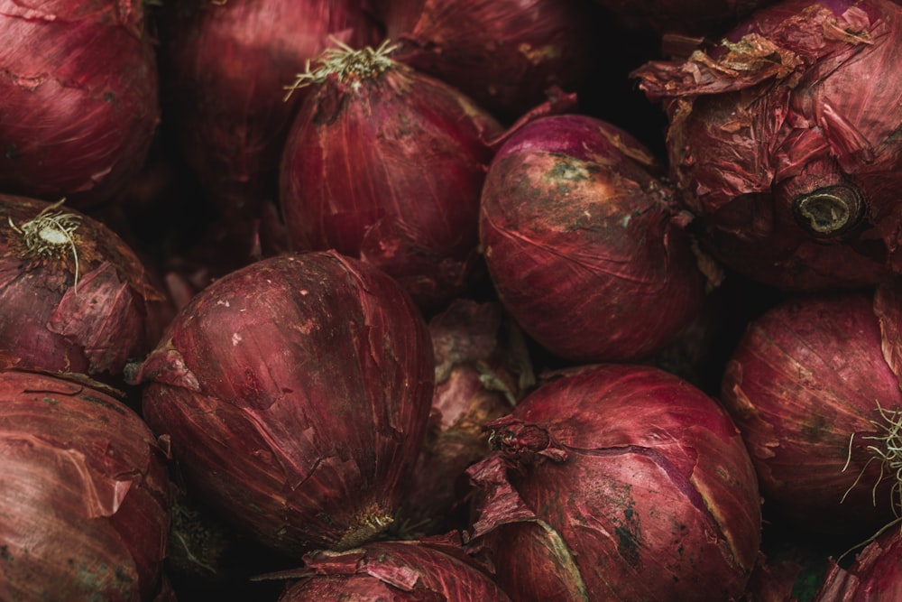a pile of red onions sitting next to each other