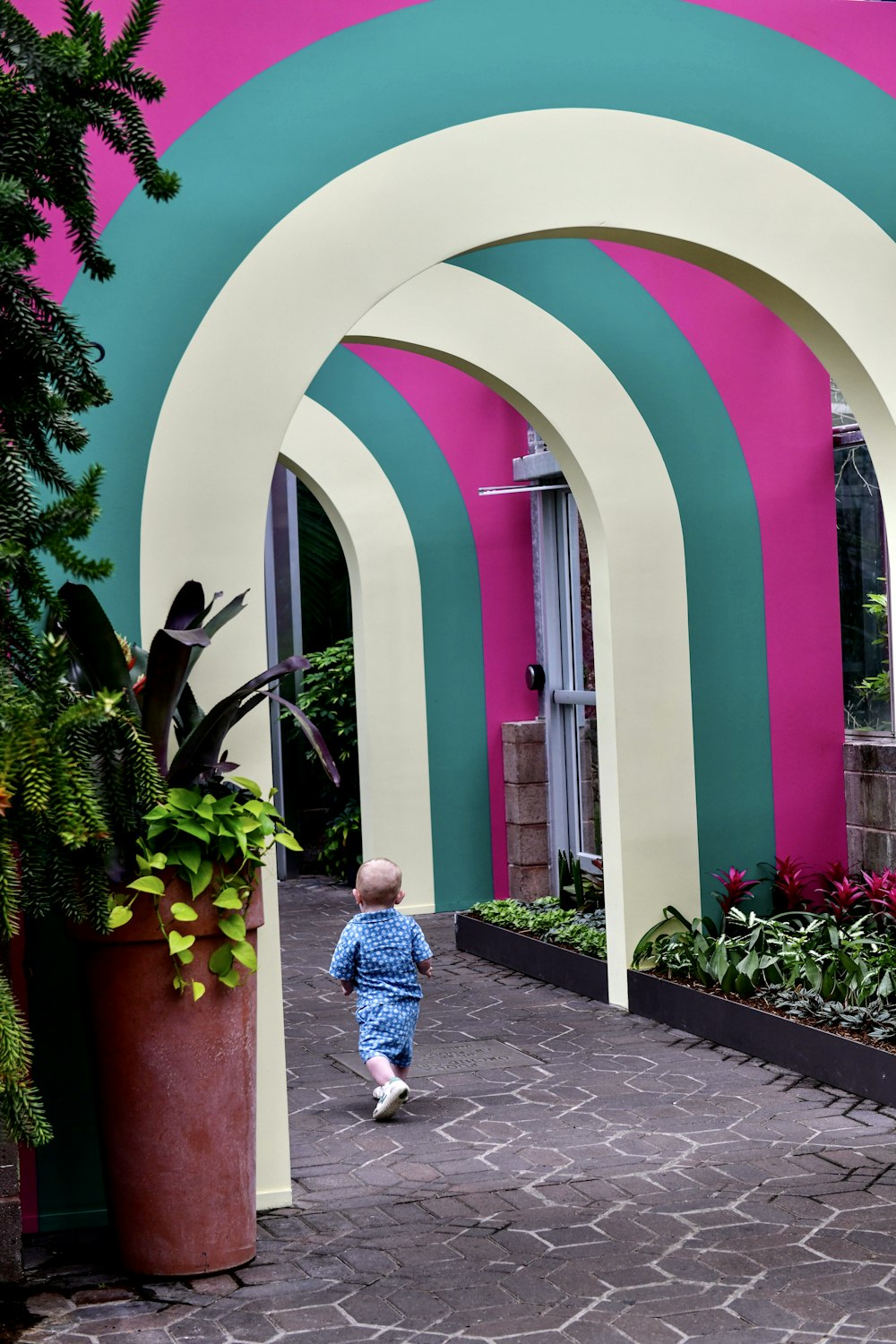 a small child walking down a walkway in front of a building