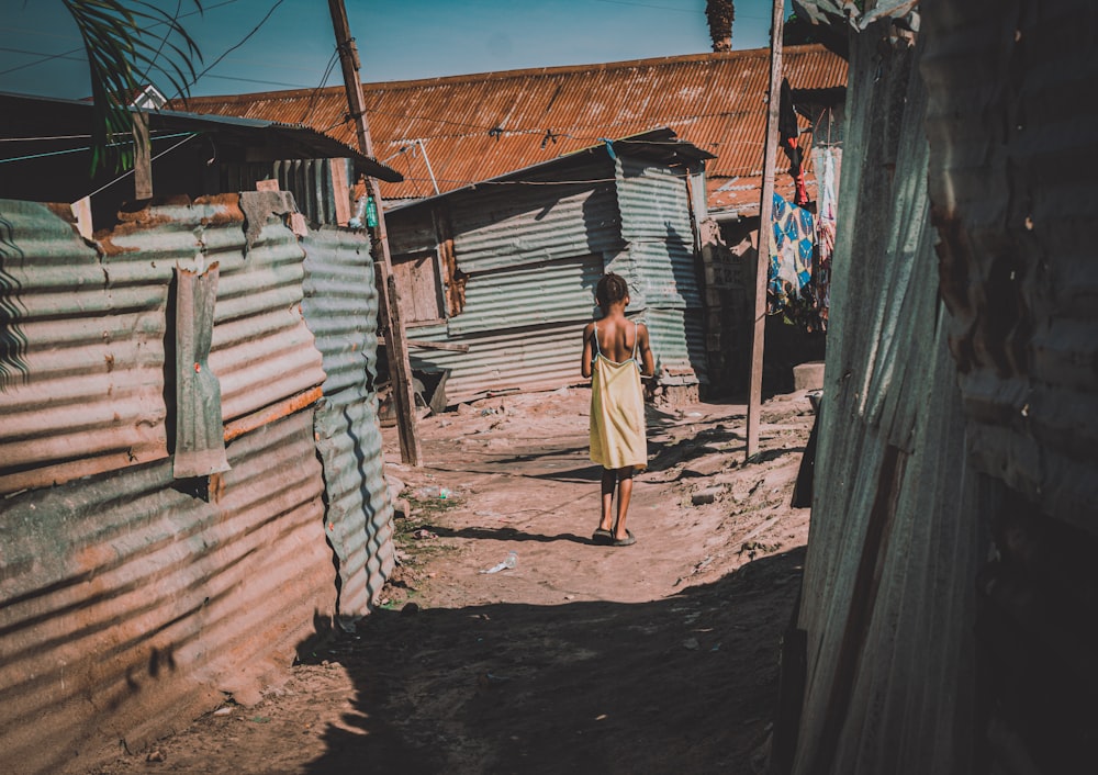 a woman walking down a [UNK] road next to [UNK]s