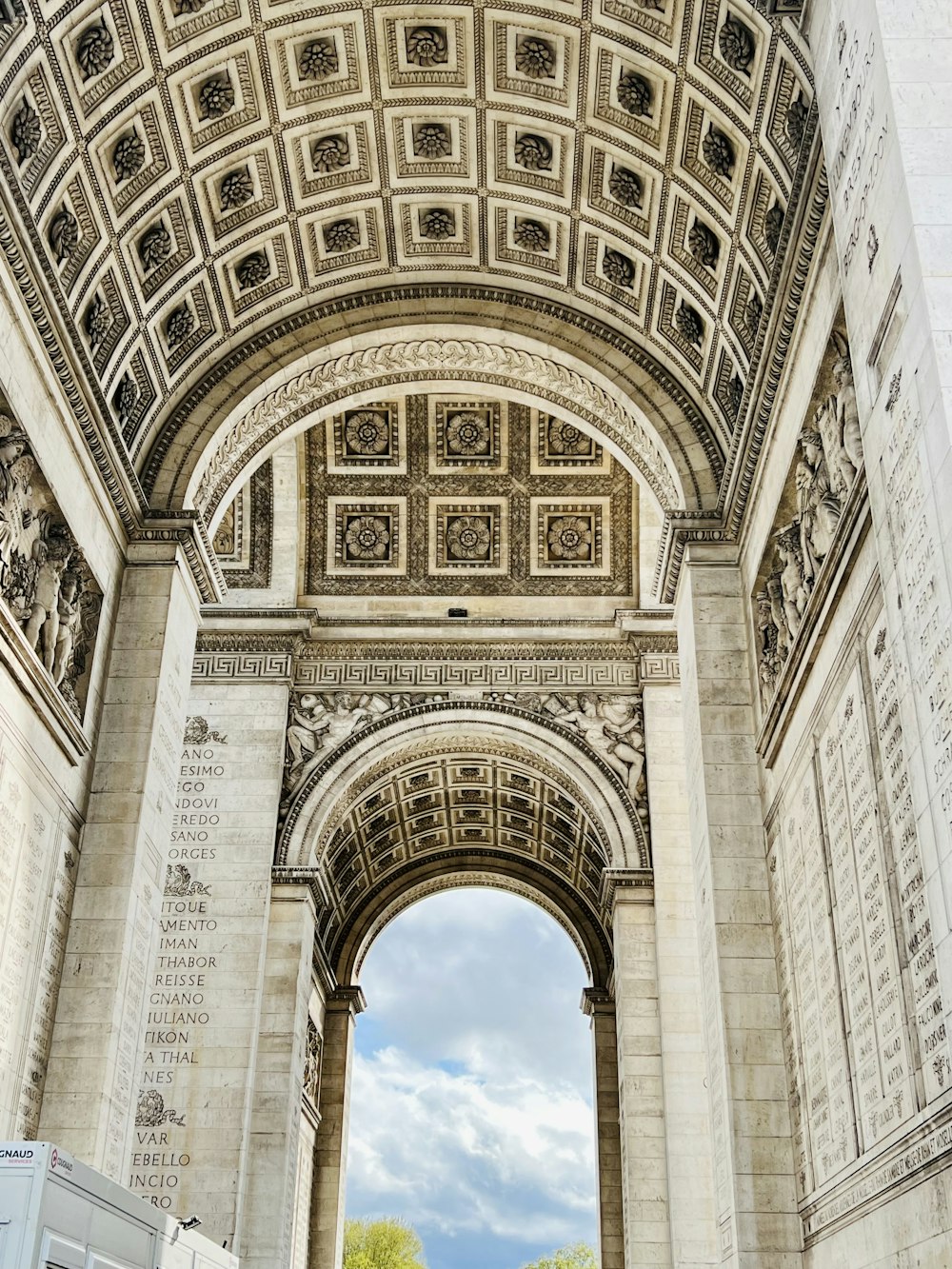 a white truck parked under a stone arch