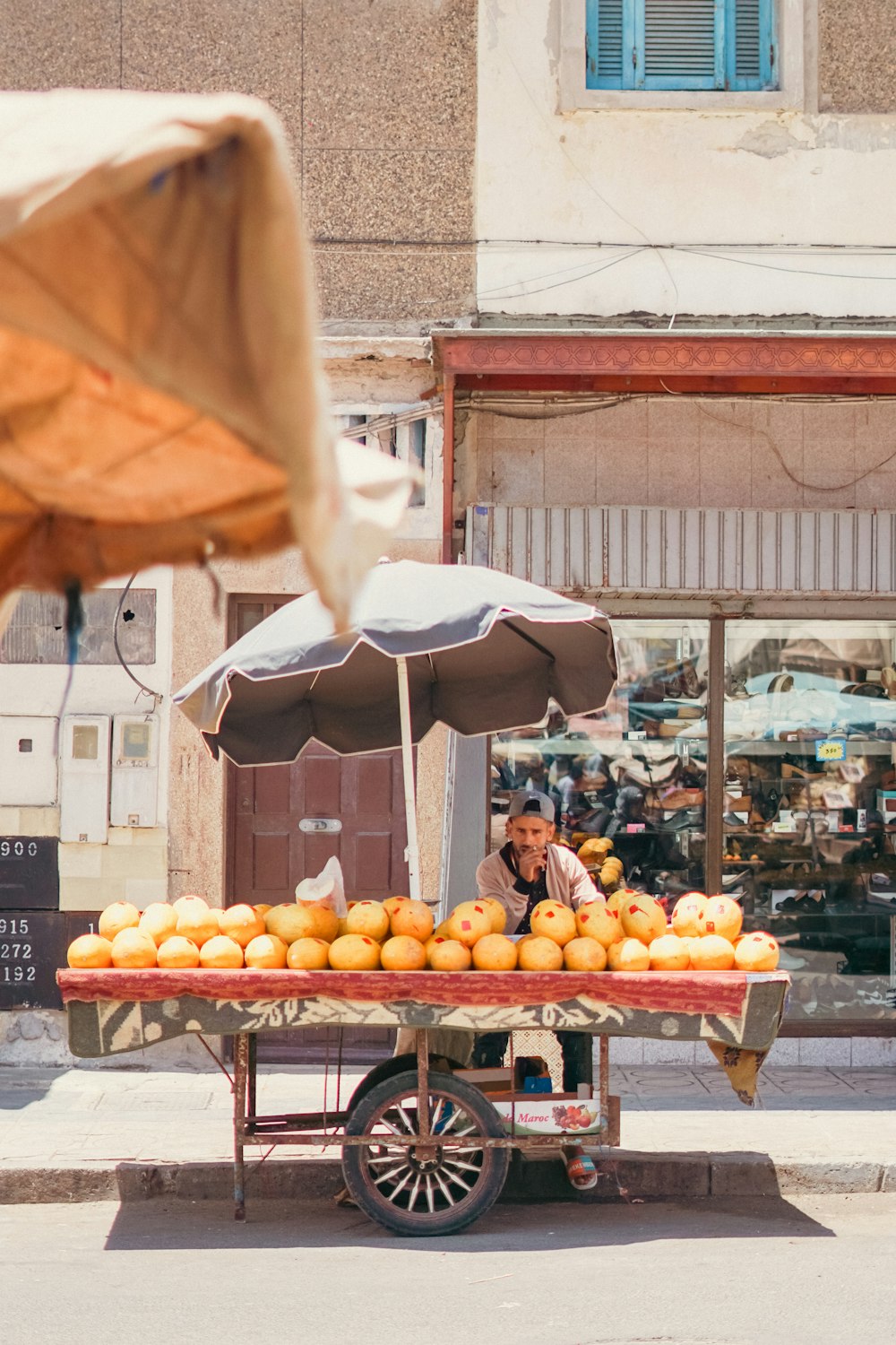 a man selling oranges from a cart on the street