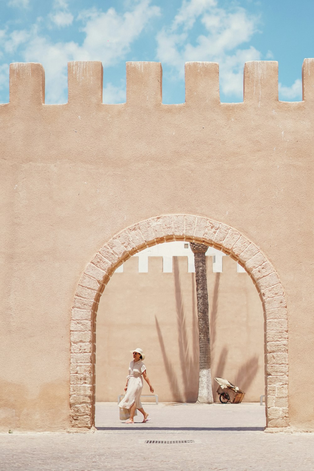 a woman walking in front of a stone [UNK]