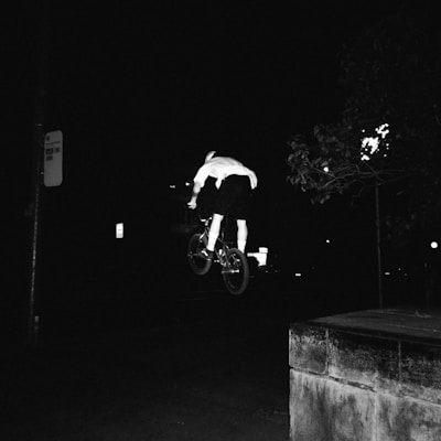 Alexandre executing a dynamic BMX race jump against a dark background