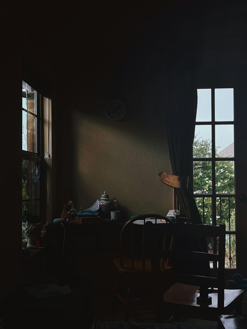 a dark room with a chair and a window