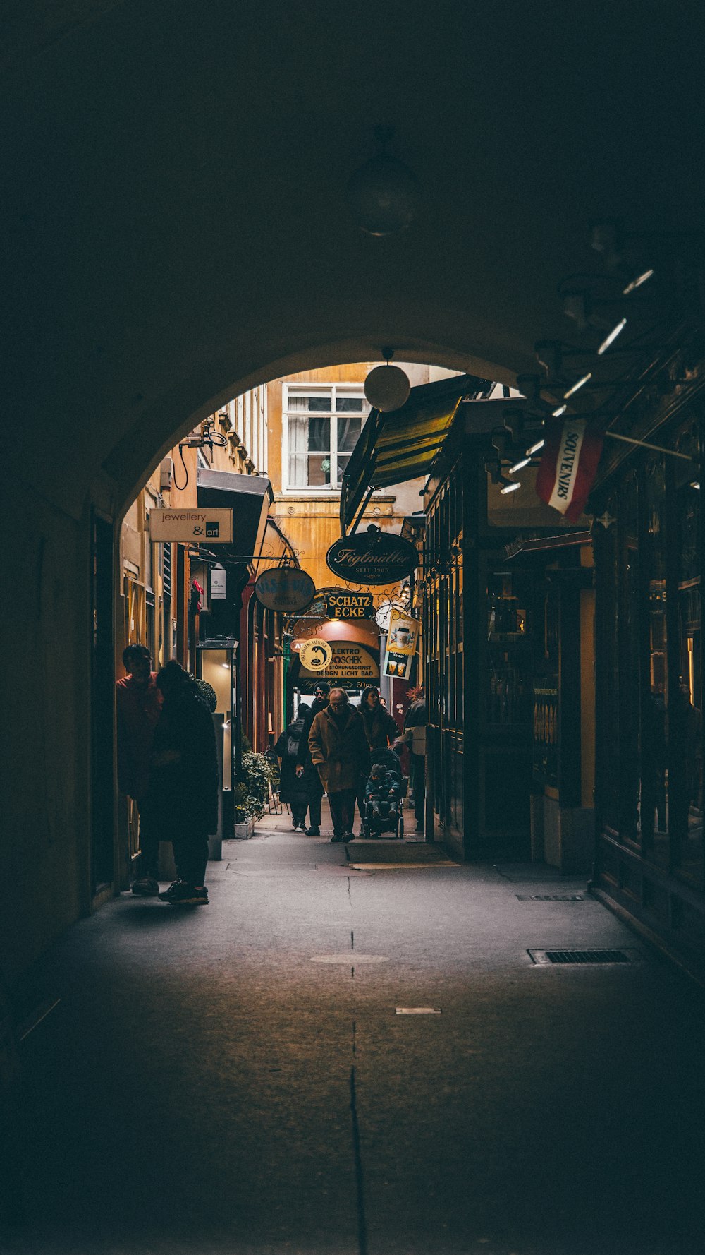 a group of people walking down a dark alley way