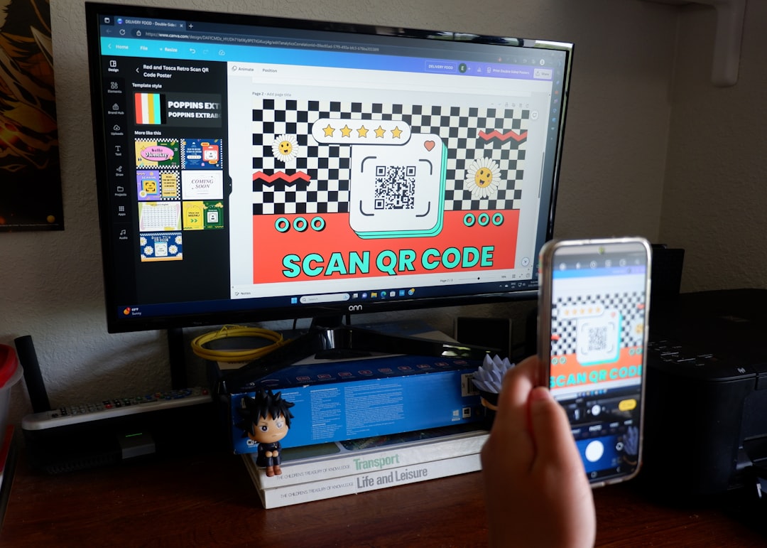 a person holding a cell phone in front of a computer screen, Create and scan QR codes from your desktop.