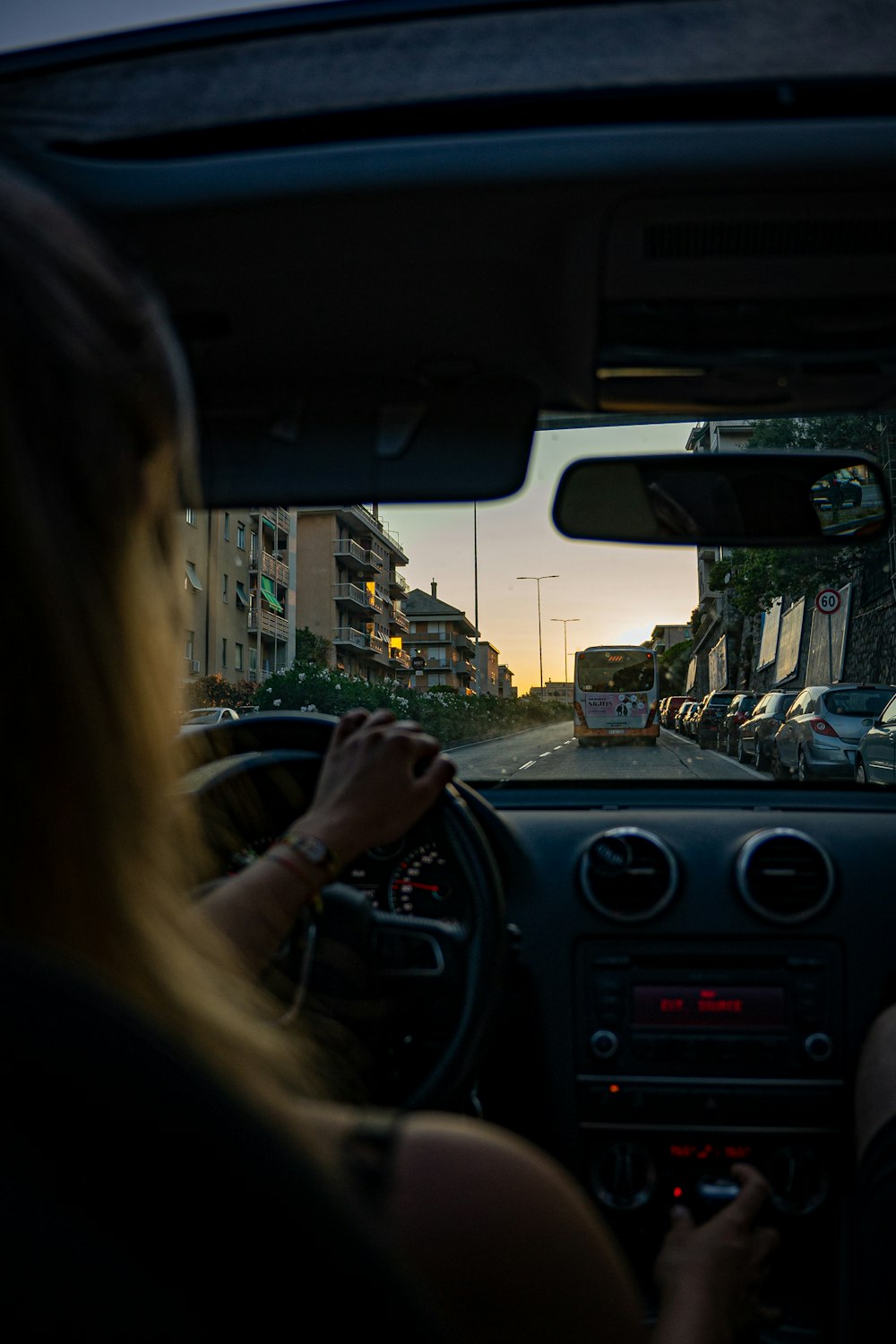a woman driving a car on a city street