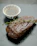 Close-up of a perfectly grilled steak resting on a dark slate plate with fresh herbs.