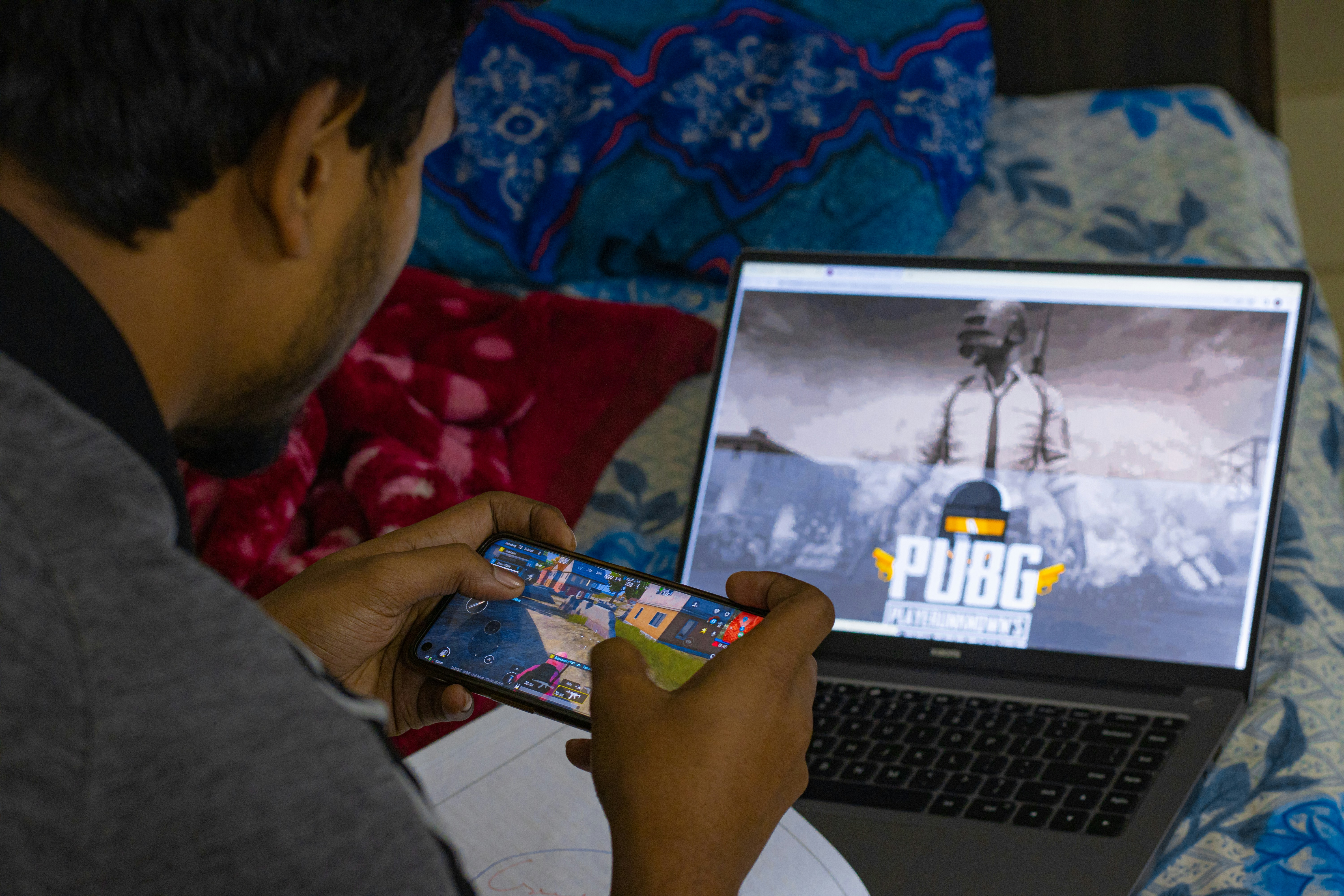 Balancing skills and priorities, this determined student enjoys a game of PUBG on his mobile, even while studying.