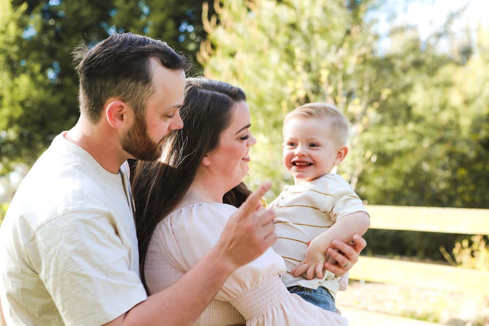 a man and woman holding a baby in their arms