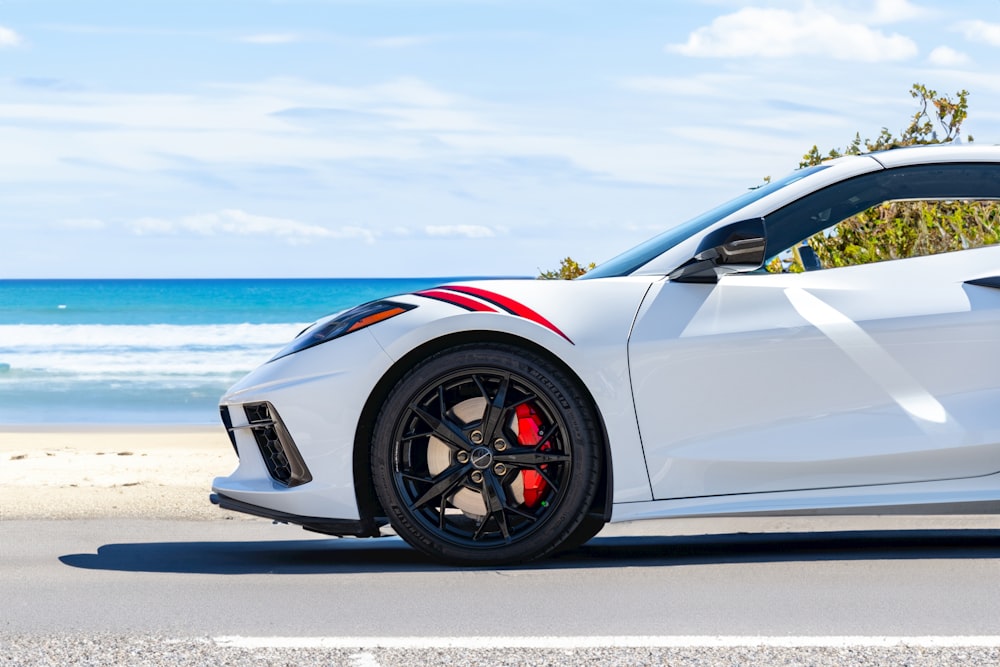 a white sports car parked on the side of the road