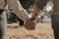 a man and a woman holding hands in a field