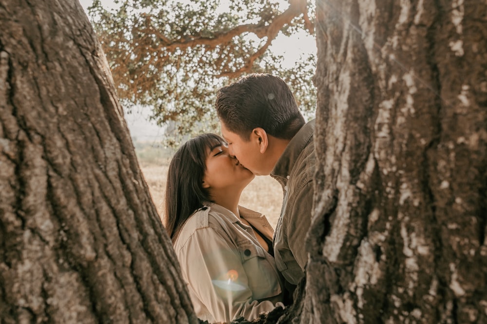 a man and woman kissing in a tree