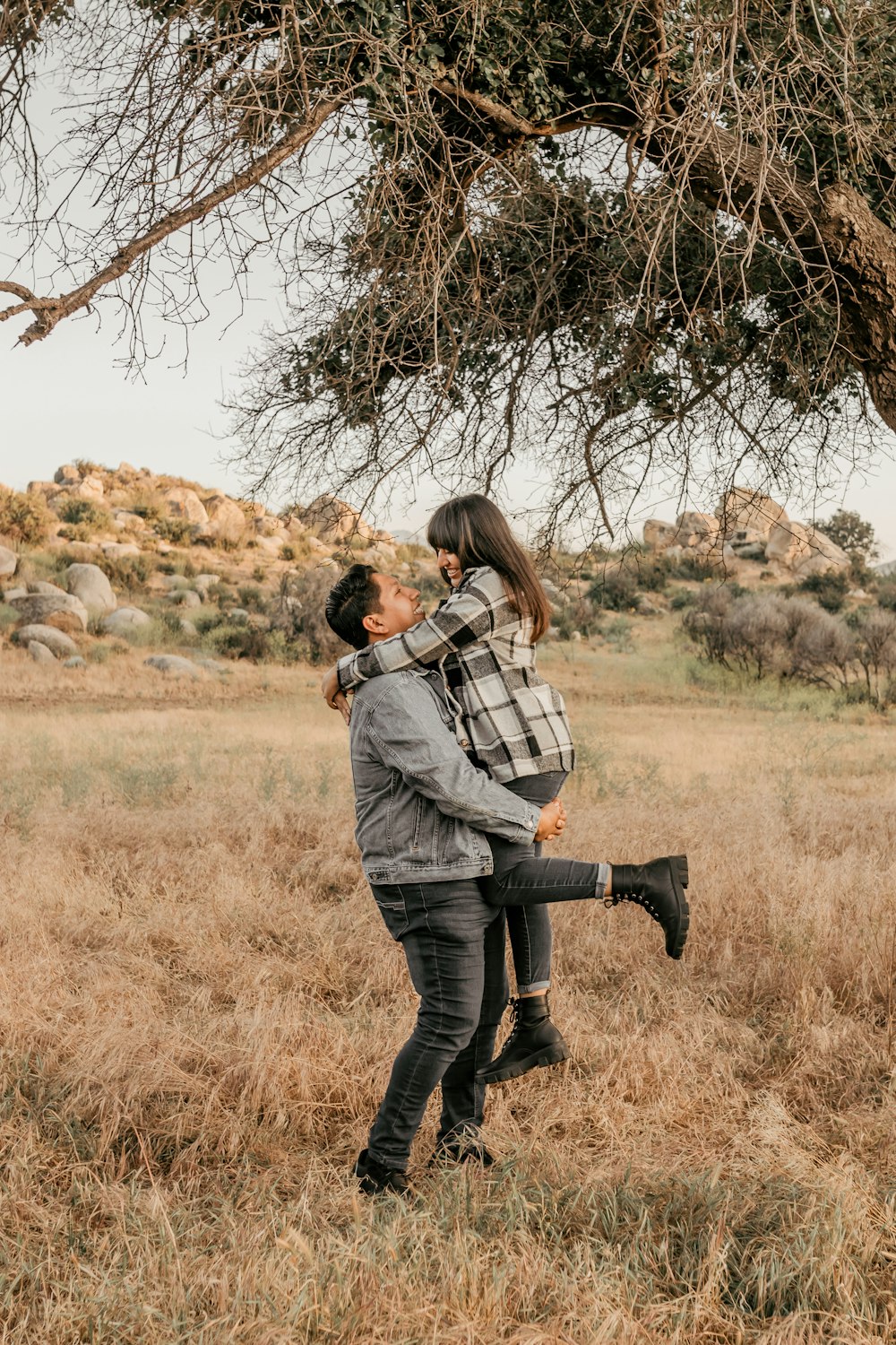 a man holding a woman under a tree