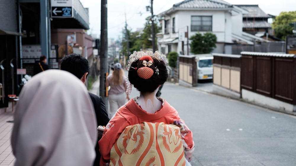 a woman in a geisha outfit walking down the street