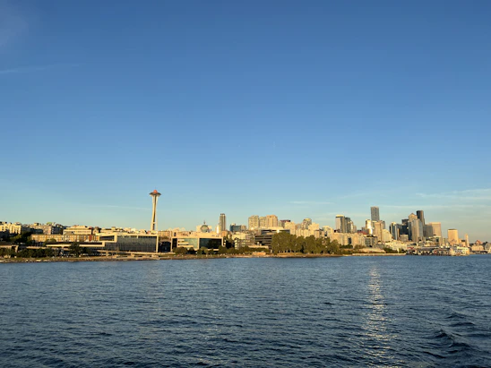 A group of engineers collaborating over blueprints with the Seattle skyline in the background.