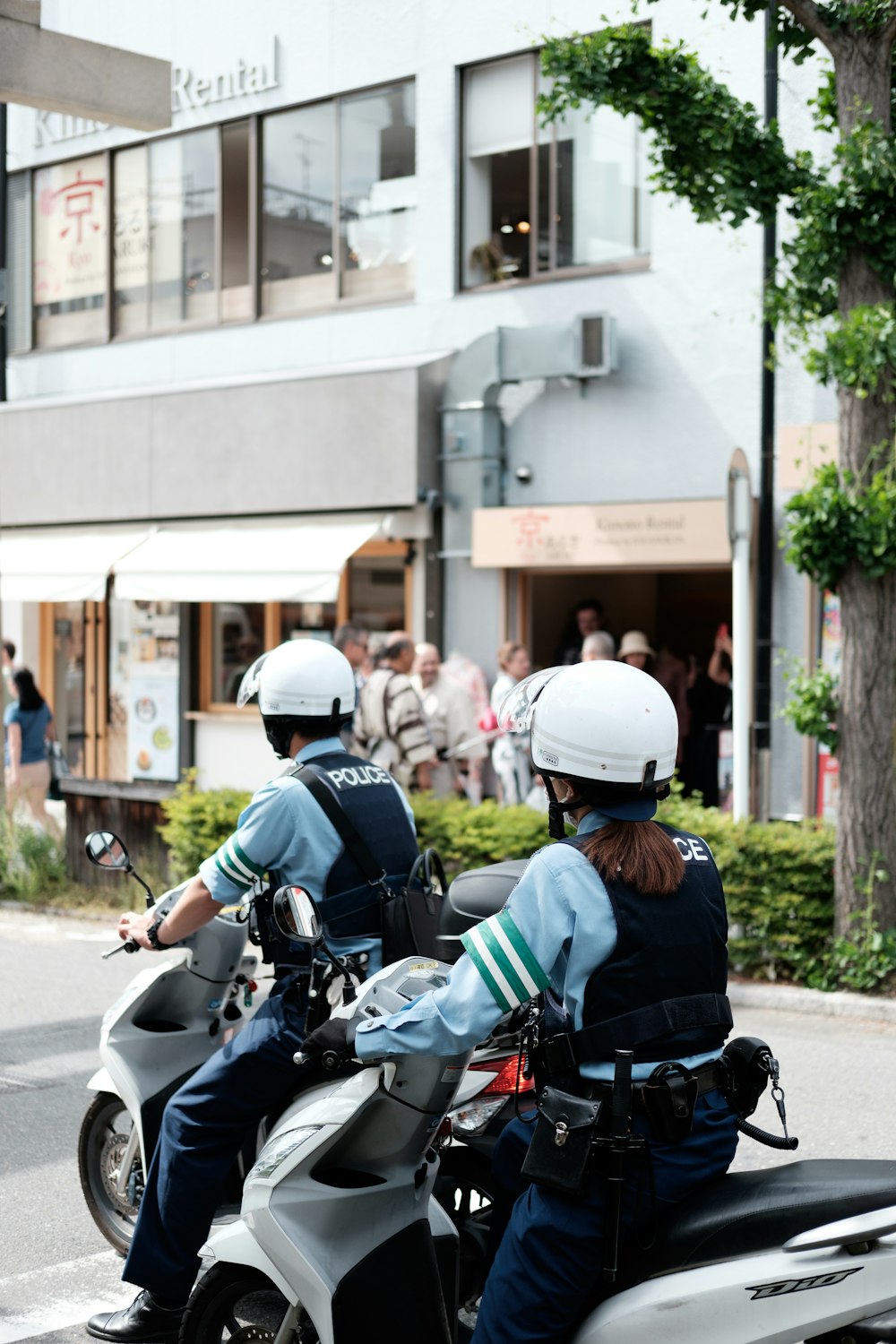 two police officers riding on the back of a motorcycle