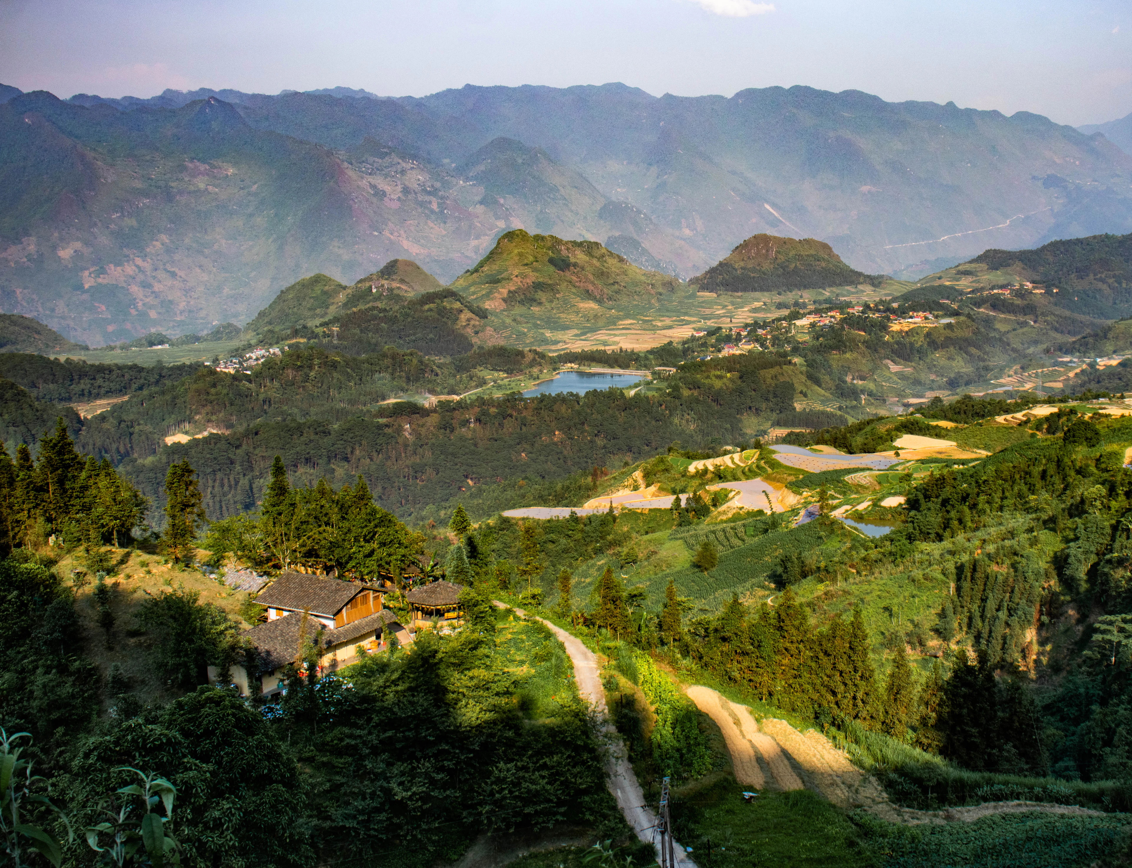 A mountain valley with village houses, fields and a winding road, Ha Giang province