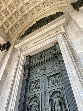 Close-up of intricate bronze details on the royal doors of Iga Ereko, glowing warmly in afternoon light.