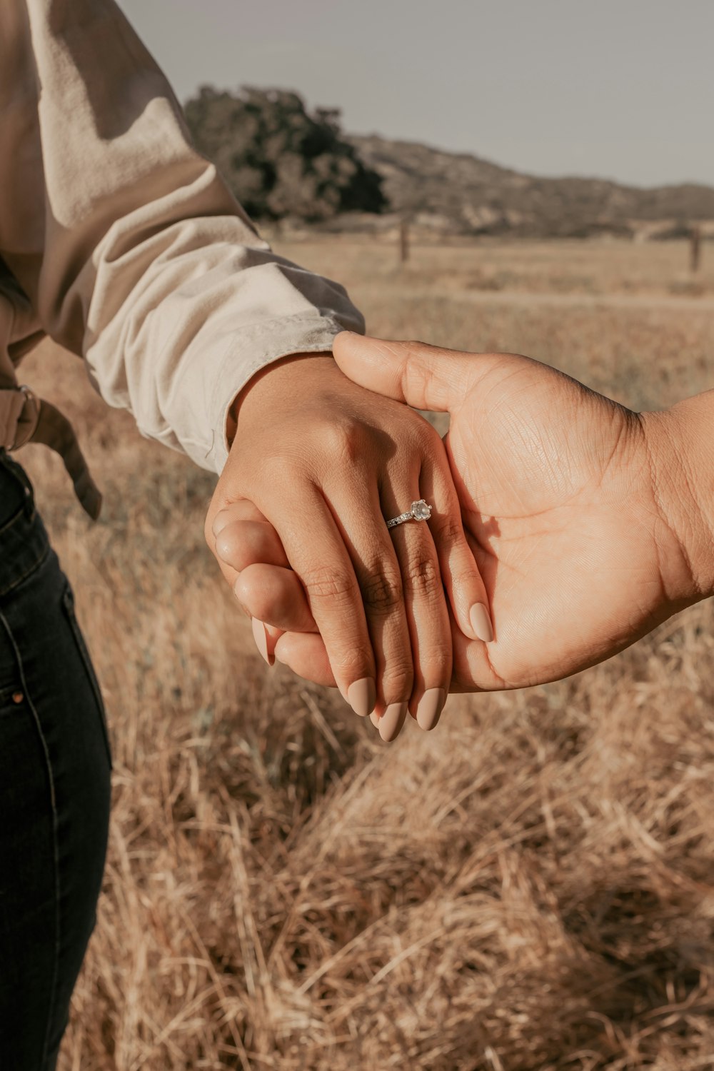 a person holding the hand of another person in a field