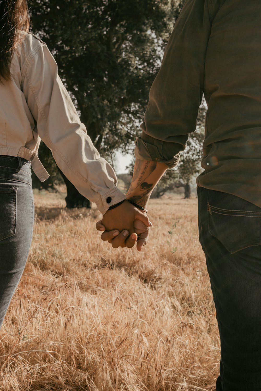 a man and a woman holding hands in a field