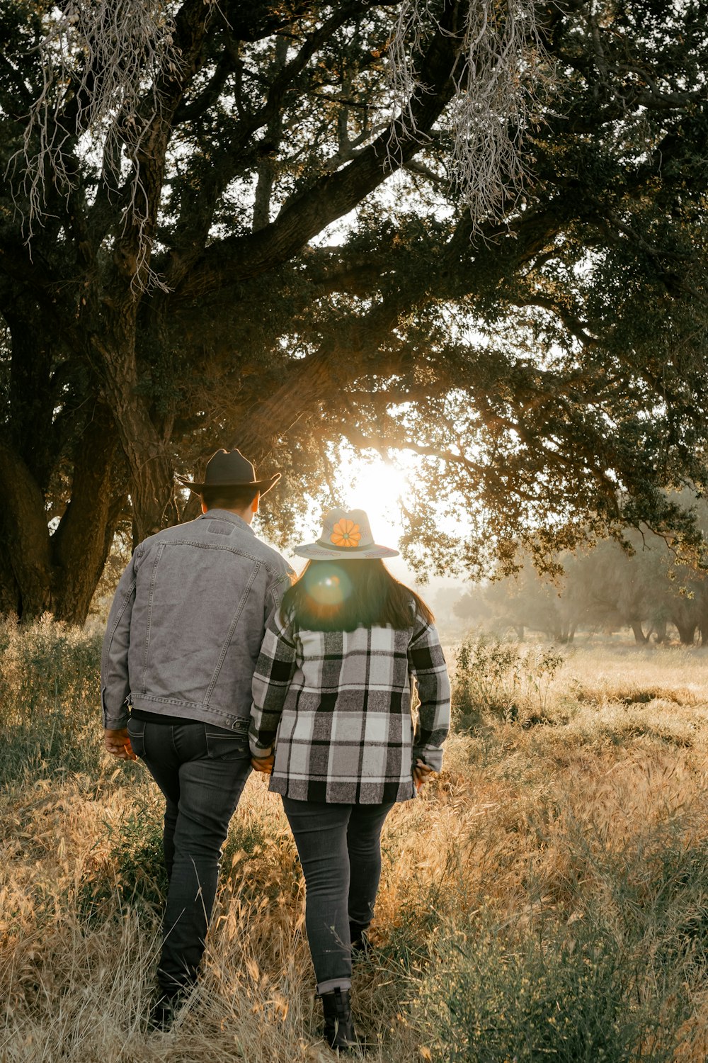 a couple of people walking through a field