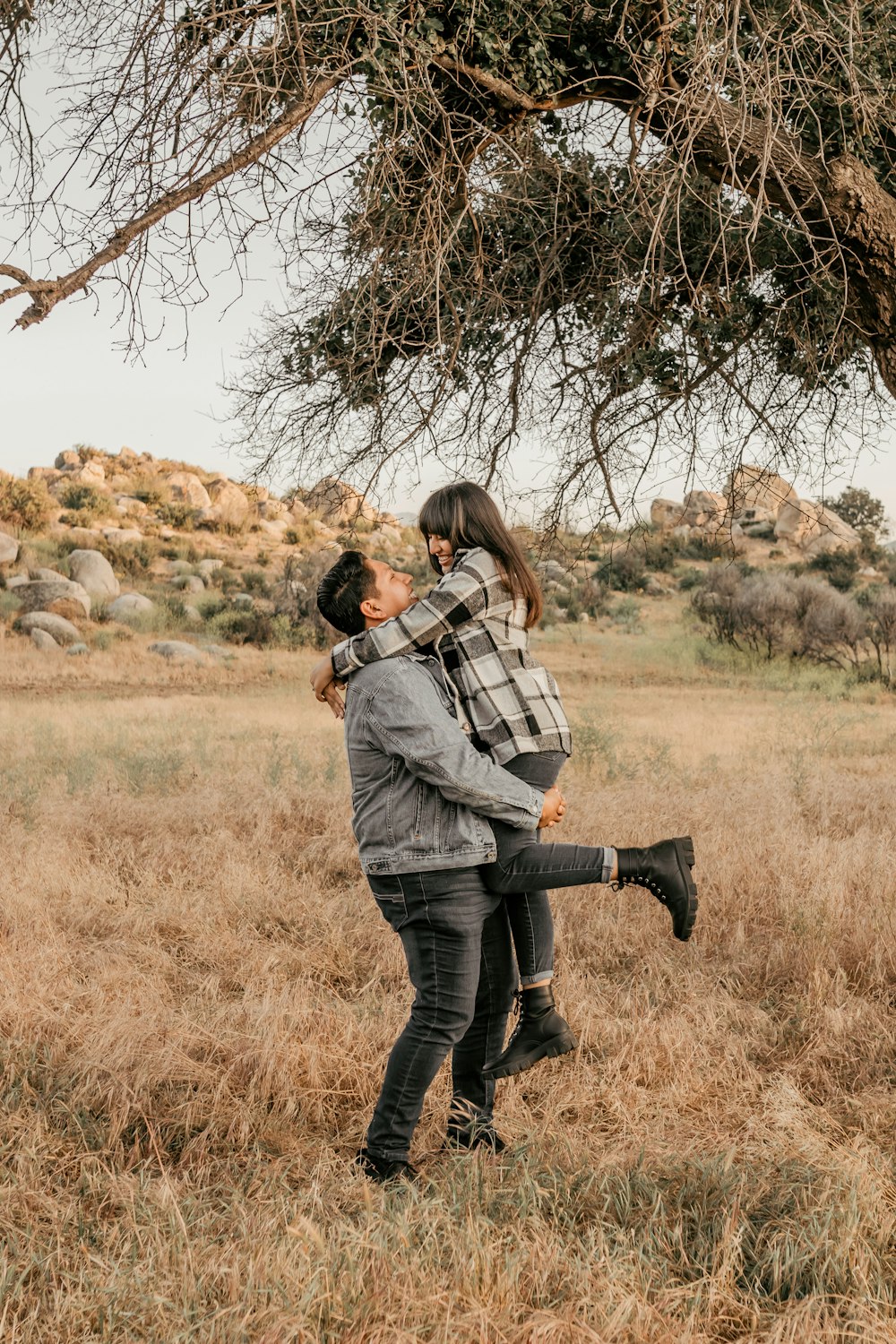 a man holding a woman under a tree