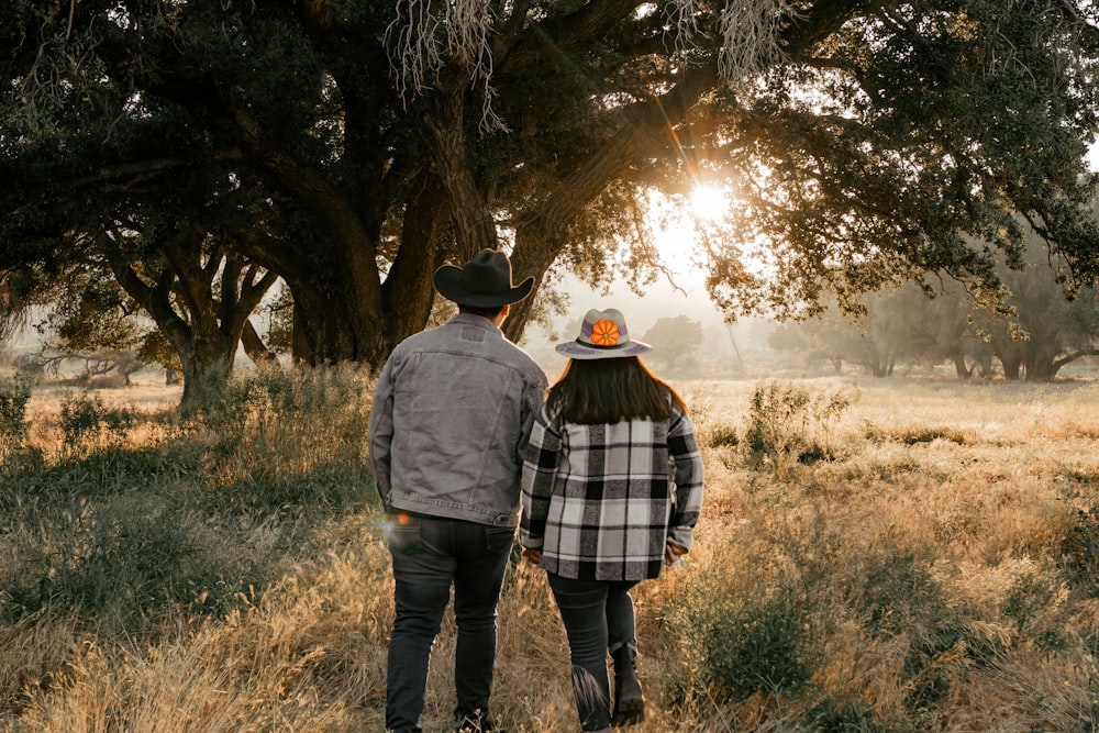 a man and a woman walking through a field