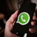 a person holding a cell phone with a whatsapp on it