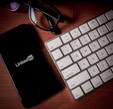 a cell phone sitting next to a keyboard on a table