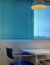 Minimalist interior with warm beige walls, sleek black furniture, and natural light highlighting textured wallpaper.