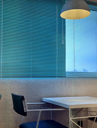 Minimalist interior with warm beige walls, sleek black furniture, and natural light highlighting textured wallpaper.