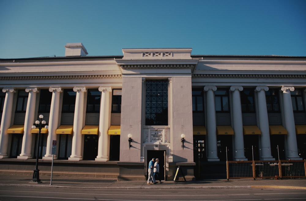 two people standing in front of a large building