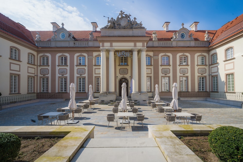 a large building with many tables and chairs in front of it