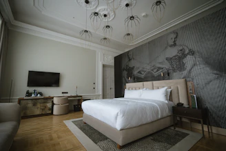 Spacious bedroom with deep purple accent walls and warm beige luxury vinyl plank flooring.