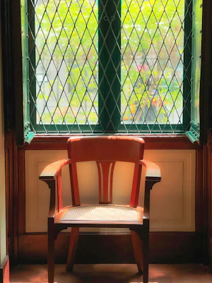 A cozy seat cushion on a wooden chair by a sunny window