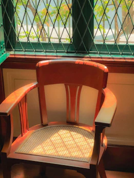 A Majuli cane rocking chair placed near a sunlit window.