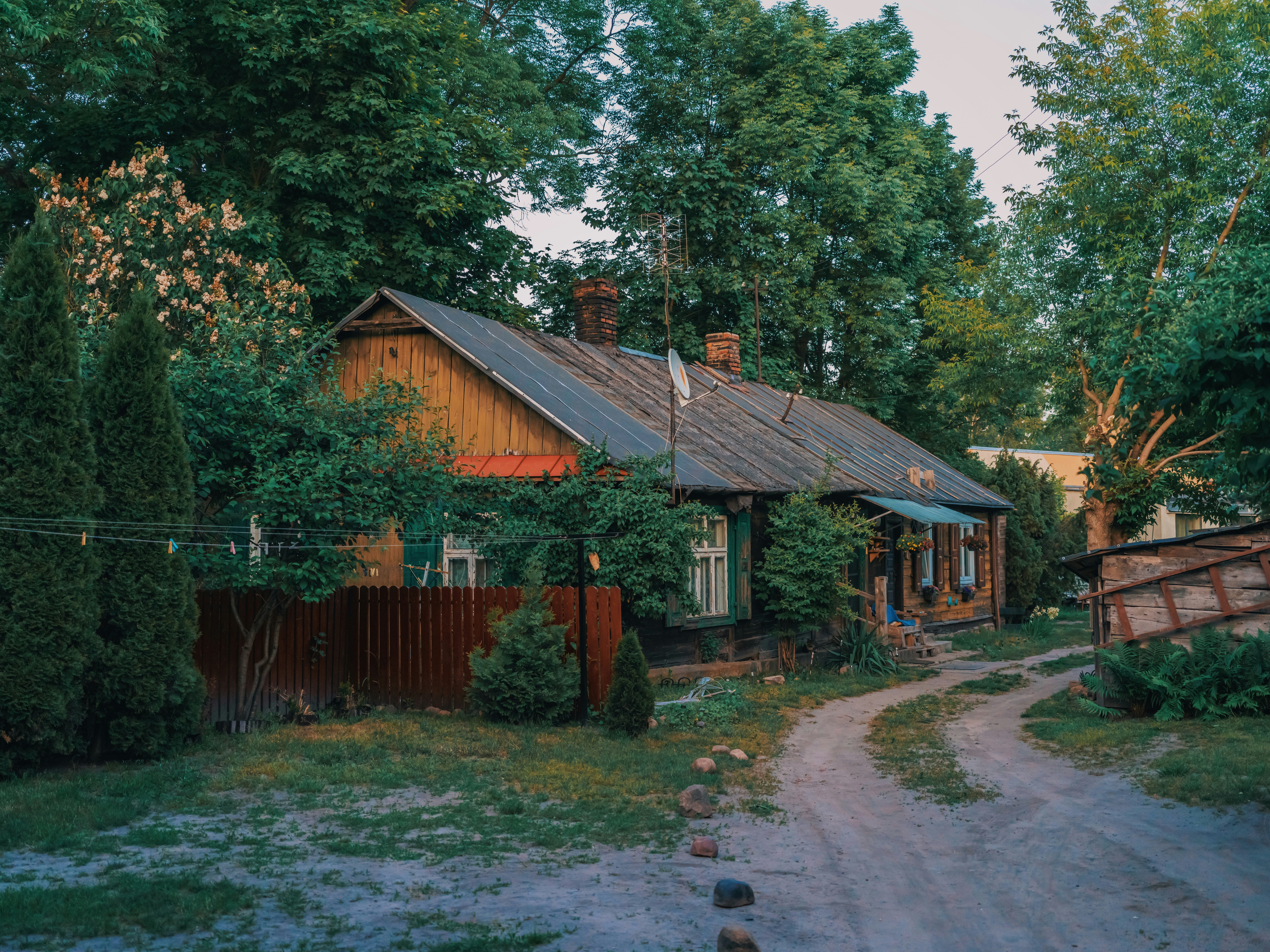 a small house with a [UNK] roof [UNK] by trees