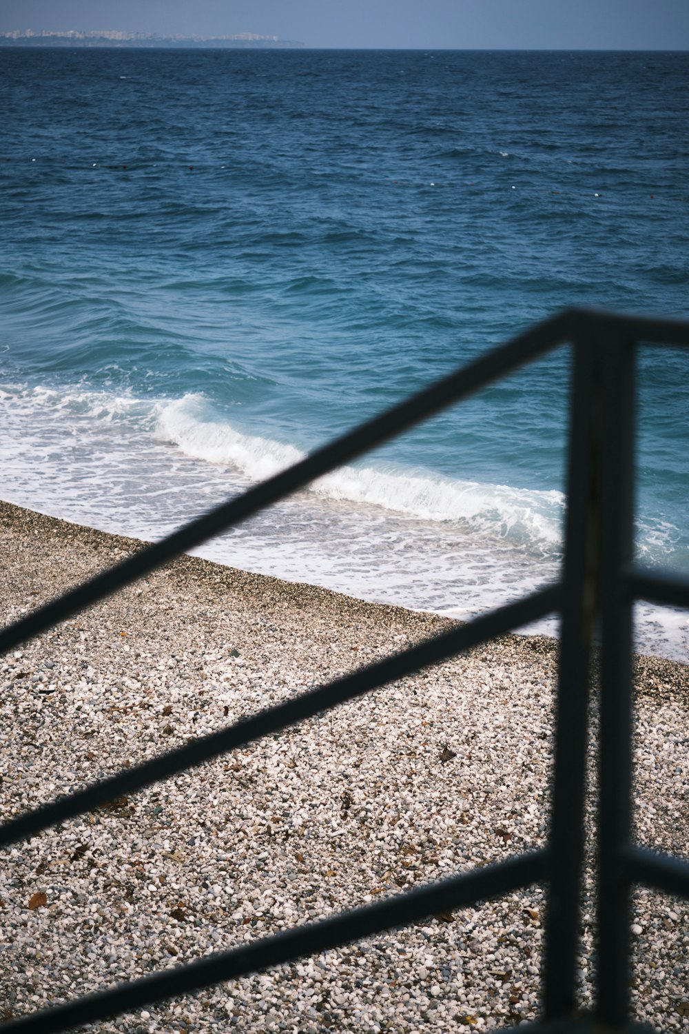 a view of the ocean from behind a fence