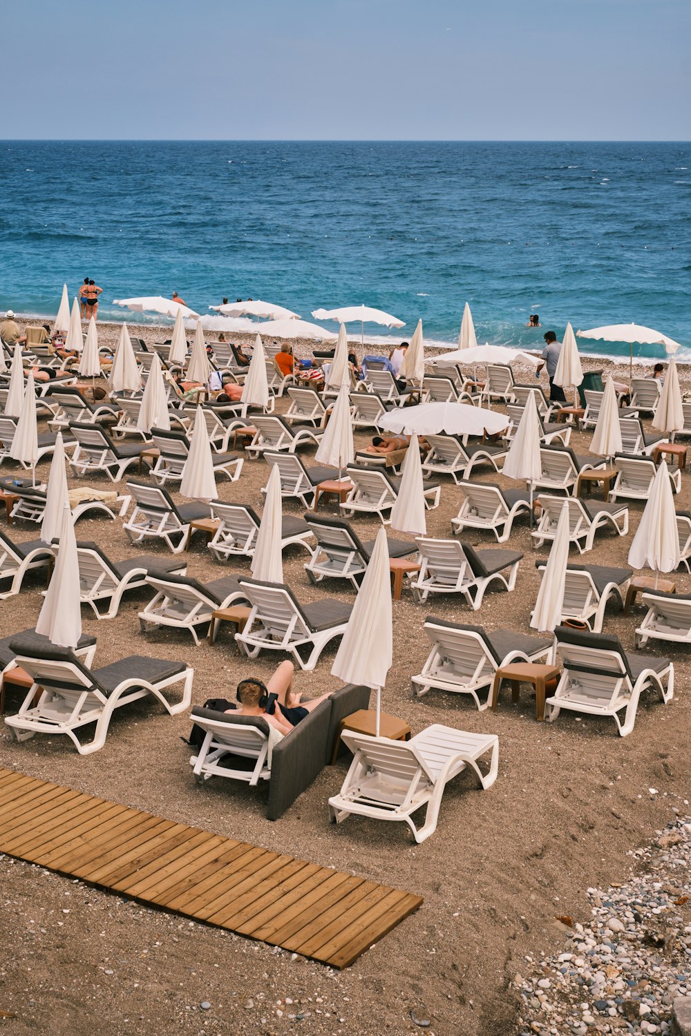 a bunch of lawn chairs and umbrellas on a beach