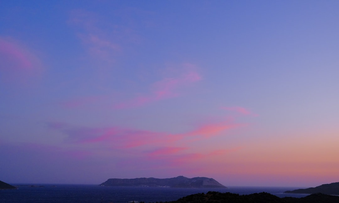 a pink and blue sky over a body of water,