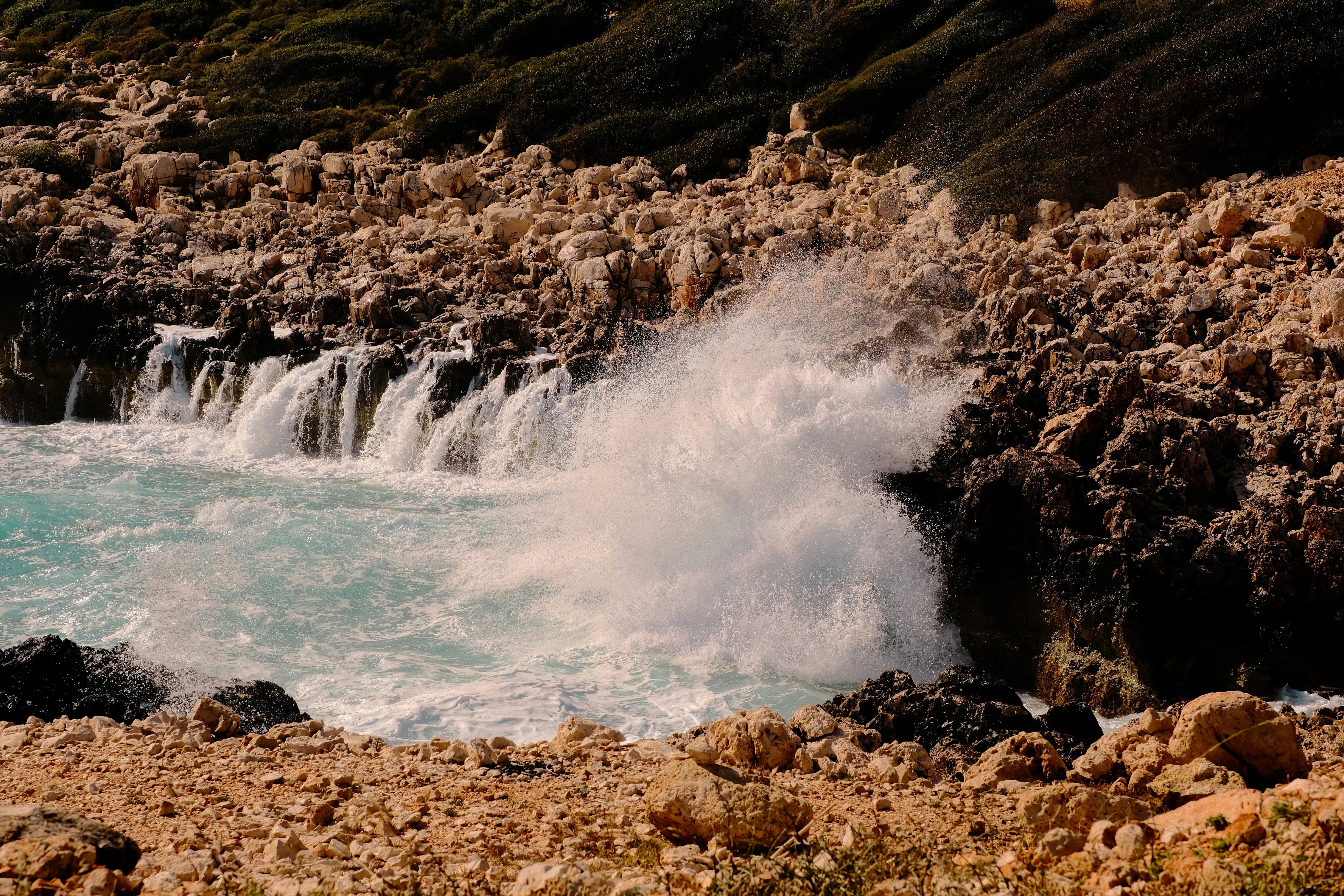 a large body of water near a rocky shore