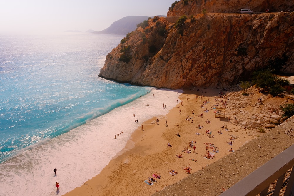 a group of people standing on top of a sandy beach