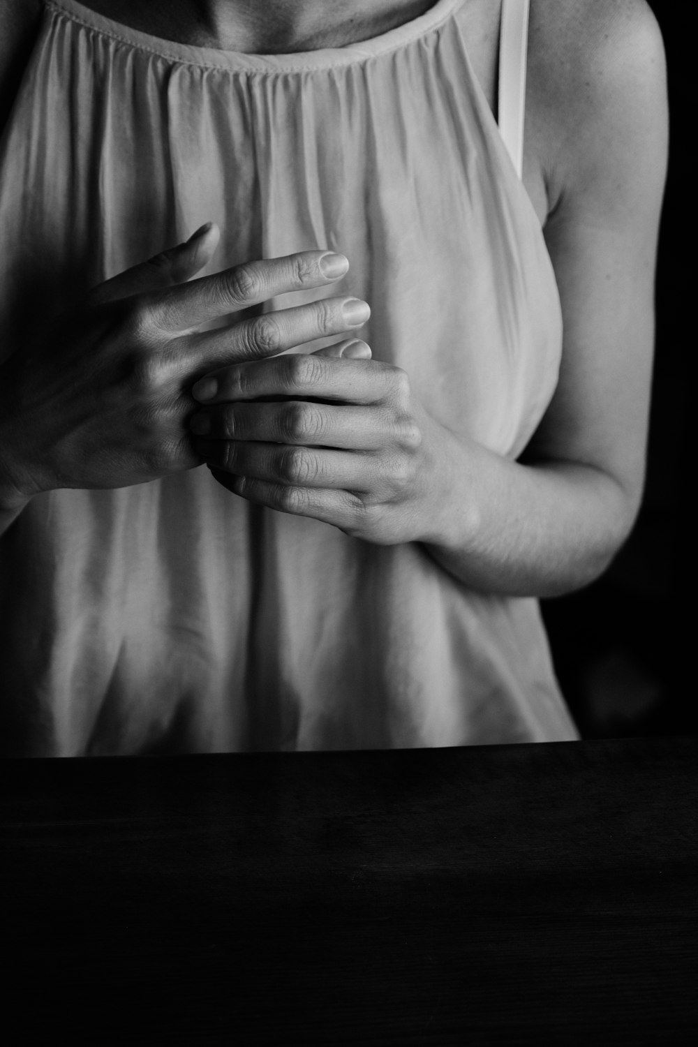 a black and white photo of a woman holding her hands together